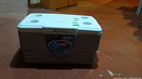 Photo of Coleman Xtreme cooler with white lid featuring cup holders and grey body, closed.