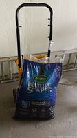Photo showing unopened blue bag of Scotts Nature Scapes Classic Black mulch on dolly.