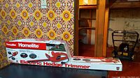 Boxed Homelite electric hedge trimmer with visible branding and product image.