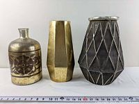 Front view of three large decorative vases showing designs and slight wear.