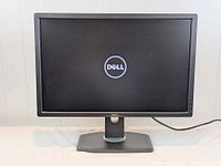 Front view of Dell U2412Mb monitor powered on showing Dell logo on screen and black bezel with stand base.