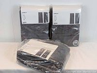 Three packs of IKEA Sanela curtains, two still unopened in packaging, one opened but gently used, all grey cotton velvet with silver grommets.