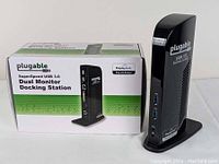 Plugable SuperSpeed USB 3.0 Dual Monitor Docking Station in black with original packaging displayed from front side showing product and branding details.