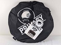 Black circular carrying bag with Privacy Pop logo printed in white, zipped closed with a tag attached.