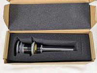 Pop-up drain inside black foam packaging and cardboard box lid