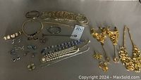 Full view of assorted costume jewelry items including bangles, bracelets, necklaces, earrings, and pearl pieces.