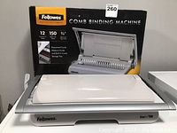 Fellowes Star+ 150 comb binding machine in closed position in front of original product box.