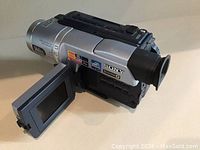 Sony DCR-TRV140 digital camcorder with flip-out LCD screen shown from side angle.