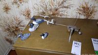 Photo showing four wooden loon bird figurines and one Otagiri kinetic bird sculpture on a brown surface with botanical wallpaper background.
