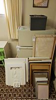 Frames stacked on top of white boxes with various sizes and colors visible.
