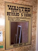 Front view of wanted poster style mirror showing text and reflection.