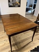 Full open view showing two drop leaves extended, curved edges, cabriole legs and apron drawers