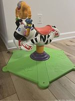 Full side view of the zebra bouncing toy mounted on a green base.