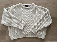 Full front view showing the cable knit pattern and overall condition of the sweater.