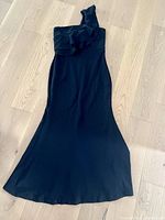 Black Lulus one shoulder mermaid dress laid flat on a wooden floor showing the full length, flared bottom and hem condition.