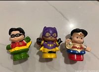 Front view of three Little People figures: Robin, Batgirl, Wonder Woman
