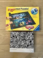 Box for Ravensburger roll up puzzle mat showing brand and piece capacity 300-1500 pieces, with instructions image.