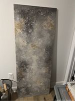 Full view of the painting leaning against a wall showing its vertical rectangular shape and color palette.