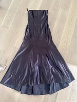 Full front view of the brown satin strapless gown laid flat showing fit and flare silhouette.