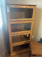 Front view of the 4-tier bookcase showing all glass-front sections and knobs