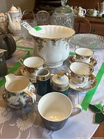 Overall photo of tea set items including teacups, cream and sugar, and other pieces on table