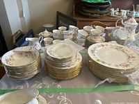 Overview of three stacks of plates and bowls on table under green tape boundary