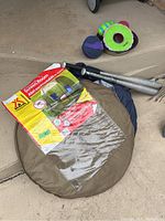 Two round carrying cases for pop-up screen room tents with packaging showing tent features and use.