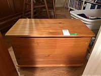 Front view of wooden toy chest showing smooth surface and slight wear marks.