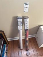 Two boxed packages of Artscape window films standing side by side on wooden floor next to a wall.