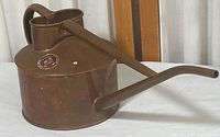 Full angled view of the copper Haws watering can showing the body, spout, and handle with natural patina and dent.
