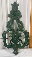 Full view of green cast iron candleholder showing overall shape and two candle sockets