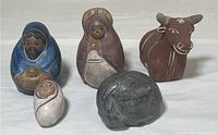 Full set of five painted South American pottery figurines including human figures, a bull, and a small gray piece.