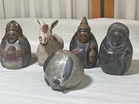 Set of five South American pottery figurines on white surface, showing overall lot contents including animal and human figures