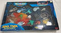 Full boxed set showcasing the 16 miniature Star Trek vessels behind clear window, with some visible wear on the box.