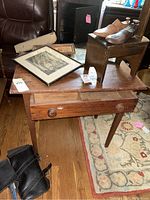 Antique wooden desk with single drawer, surface with scratches, drawer open showing two compartments.