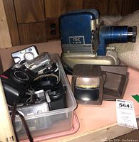 Photo showing bin with multiple cameras and two slide viewers on table