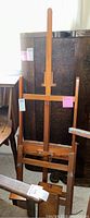 Full front view of wooden artist's easel with adjustable vertical support and horizontal crossbar.