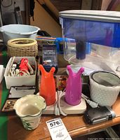 Overview of various lot items including night lights, plant pots, shoe laces, water filter jug, Aleve therapy, flashlight and Pocket Fisherman