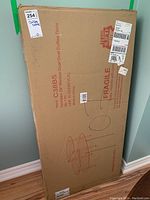 Box containing the dual oval coffee tables with measurements and fragile label visible.