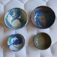 Top-down view of the four pottery bowls, showing different artistic glazes and sizes.