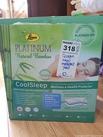 Front view of the box showing brand, model, and key selling points like natural bamboo material, waterproof and breathable properties, and size (Queen).