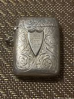 Front view of the sterling silver match case with scroll engraving and inscription 'From Him 1837'.