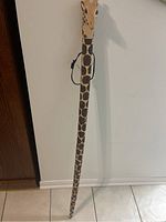 Full view of the walking stick showing the full length and giraffe pattern.