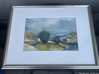 Framed watercolor landscape painting depicting hills, trees, and a house, measuring approximately 16.5x20.75 inches.
