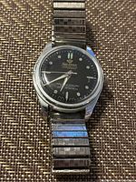 Front face of the vintage Sea Diver watch showing black dial, silver markers, crown logo, and stainless steel band.