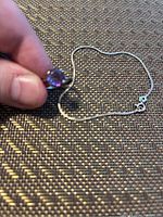 Photo showing the sterling silver bracelet chain and part of the amethyst ring held in hand.