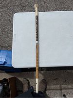 Full view of the wooden cane showing its two connected sections and overall length.