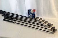 Eight Daiwa golf clubs laid out side by side with four boxes of golf balls behind them