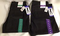 Photo of two pairs of black Nygard pull-on jeggings folded, one size 12 with green tag and the other size 14 with purple tag.