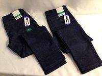Two folded pairs of blue denim Nygard pull-on jeggings laid side by side showing front and back pockets and attached tags.